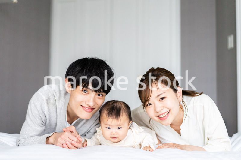 赤ちゃんと一緒に寝転ぶファミリー