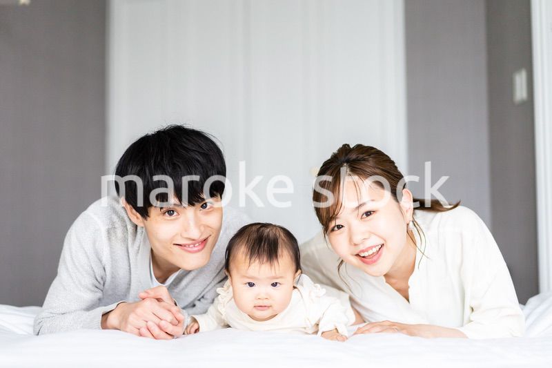 赤ちゃんと一緒に寝転ぶファミリー