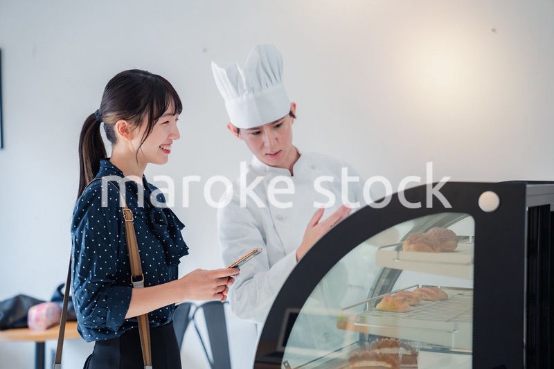 お店でスイーツを選ぶ若い女性