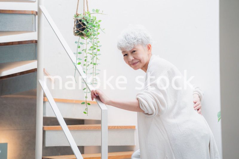 階段で腰痛に苦しむ高齢の女性