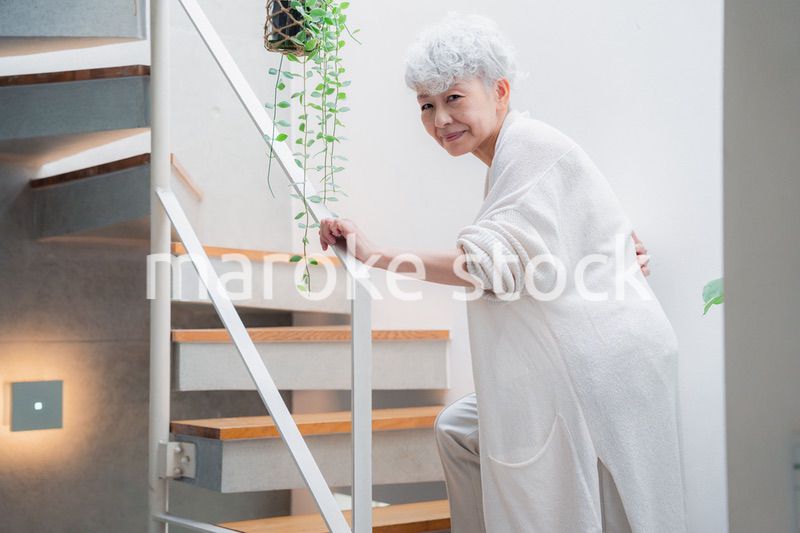 階段で腰痛に苦しむ高齢の女性