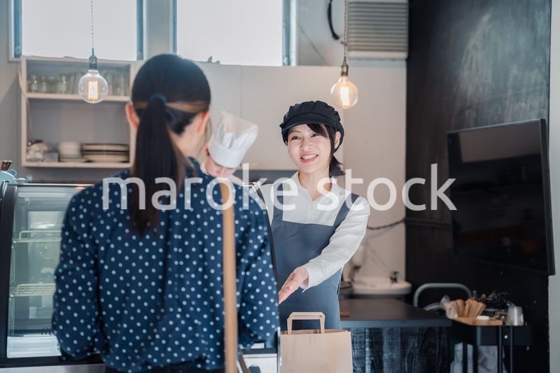 こだわりのお店でテイクアウトをする若い女性