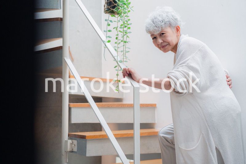 階段で腰痛に苦しむ高齢の女性