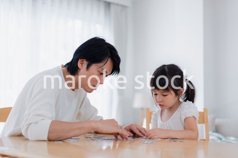 パパと一緒にパズルゲームをする小さな女の子