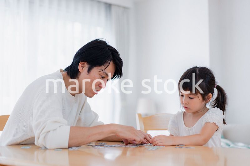 パパと一緒にパズルゲームをする小さな女の子