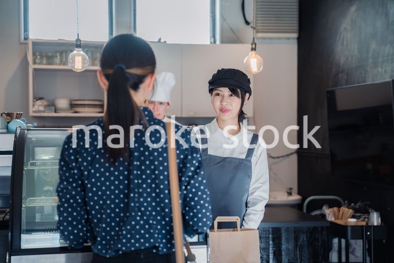 こだわりのお店でテイクアウトをする若い女性