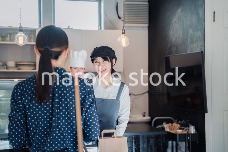 こだわりのお店でテイクアウトをする若い女性