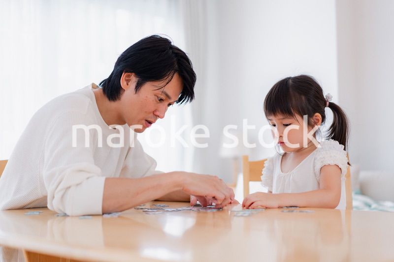 パパと一緒にパズルゲームをする小さな女の子