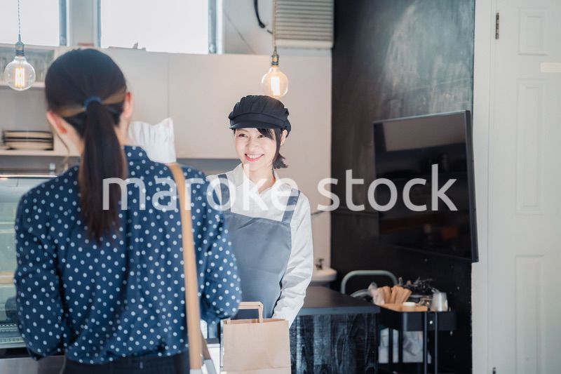 こだわりのお店でテイクアウトをする若い女性