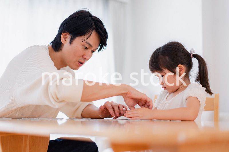 パパと一緒にパズルゲームをする小さな女の子