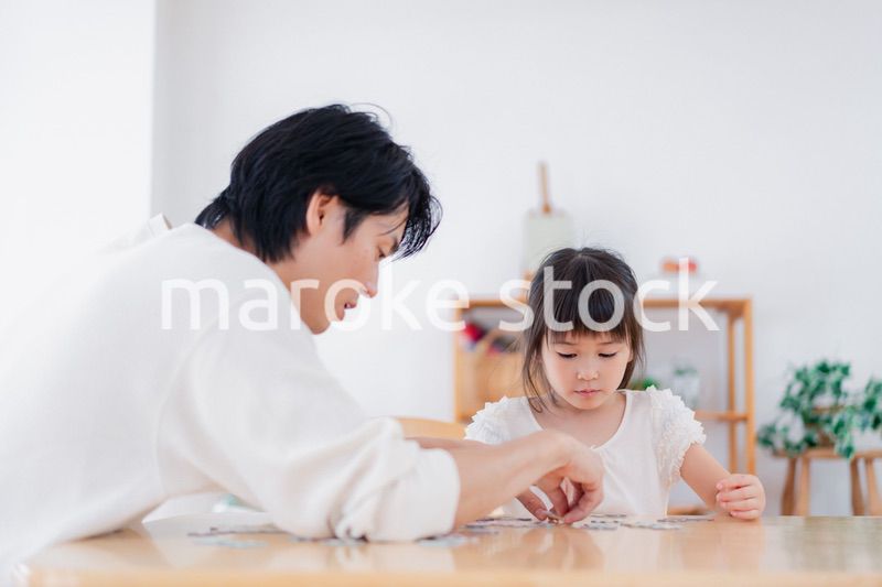 パパと一緒にパズルゲームをする小さな女の子