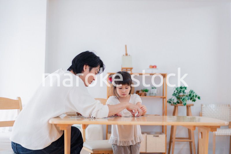 パパと一緒にパズルゲームをする小さな女の子