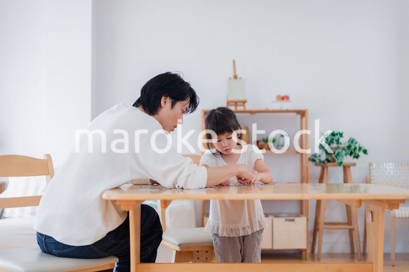 パパと一緒にパズルゲームをする小さな女の子