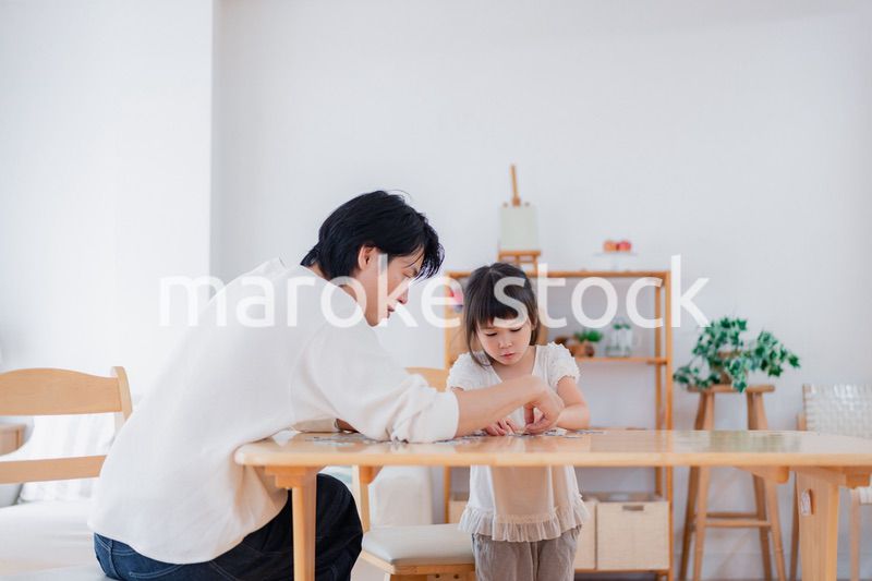 パパと一緒にパズルゲームをする小さな女の子