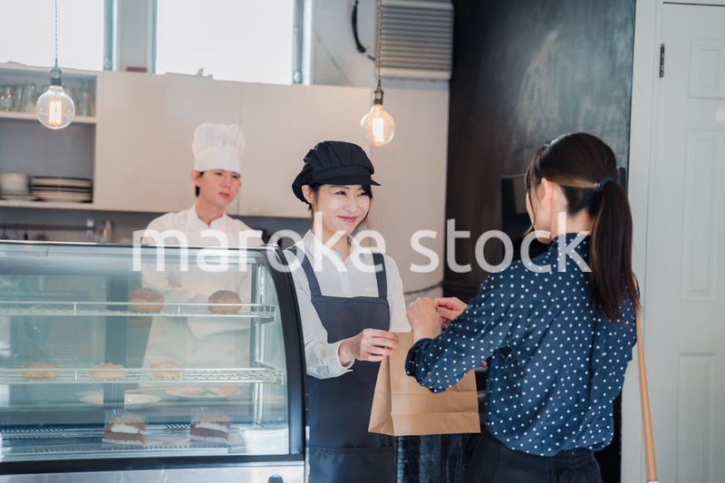 こだわりのお店でテイクアウトをする若い女性
