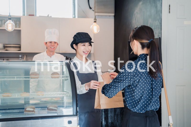 こだわりのお店でテイクアウトをする若い女性