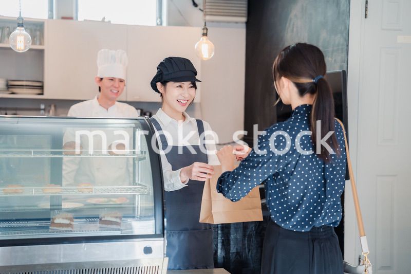 こだわりのお店でテイクアウトをする若い女性