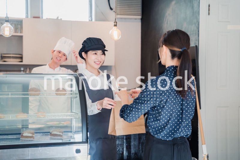 こだわりのお店でテイクアウトをする若い女性