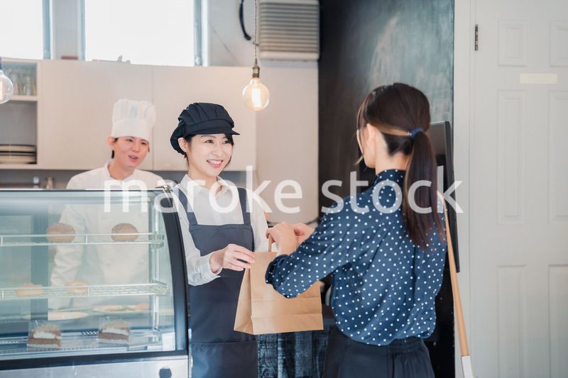 こだわりのお店でテイクアウトをする若い女性