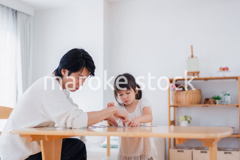 パパと一緒にパズルゲームをする小さな女の子