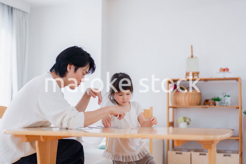 パパと一緒にパズルゲームをする小さな女の子