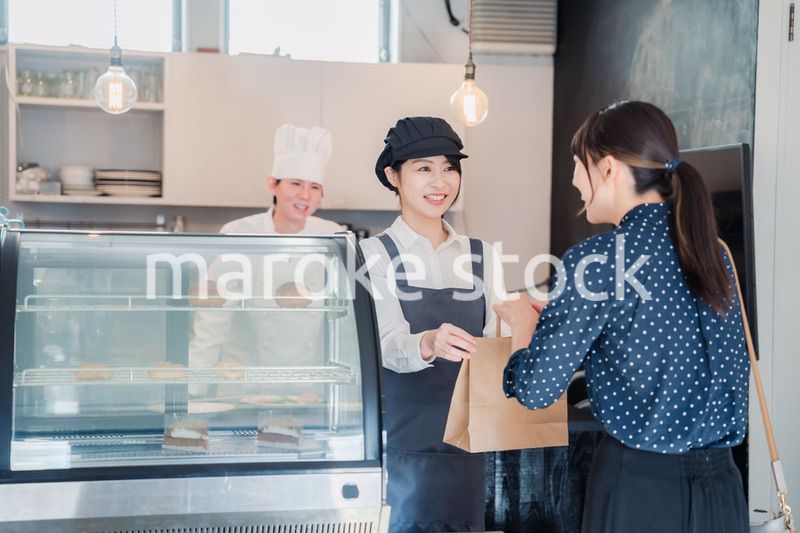 こだわりのお店でテイクアウトをする若い女性