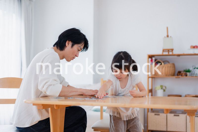 パパと一緒にパズルゲームをする小さな女の子