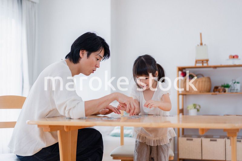 パパと一緒にパズルゲームをする小さな女の子