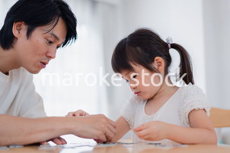 パパと一緒にパズルゲームをする小さな女の子