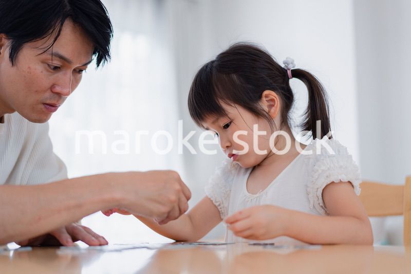 パパと一緒にパズルゲームをする小さな女の子