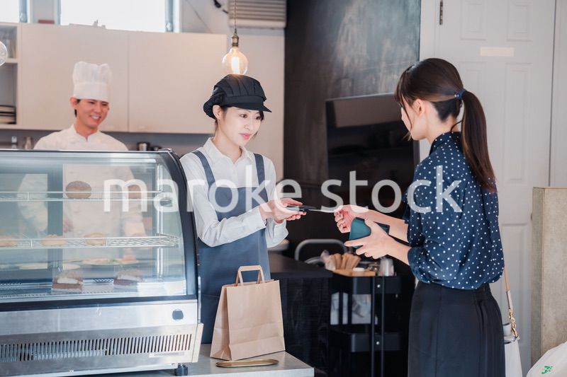 お菓子屋さんでクレジットカード決済をする女性