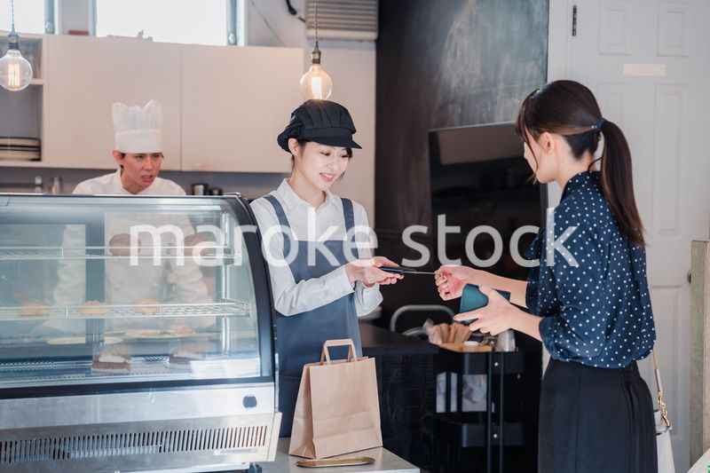 お菓子屋さんでクレジットカード決済をする女性