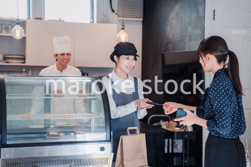 お菓子屋さんでクレジットカード決済をする女性
