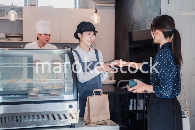お菓子屋さんでクレジットカード決済をする女性