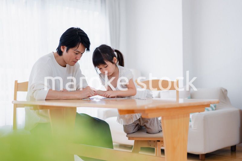 パパと一緒にパズルゲームをする小さな女の子