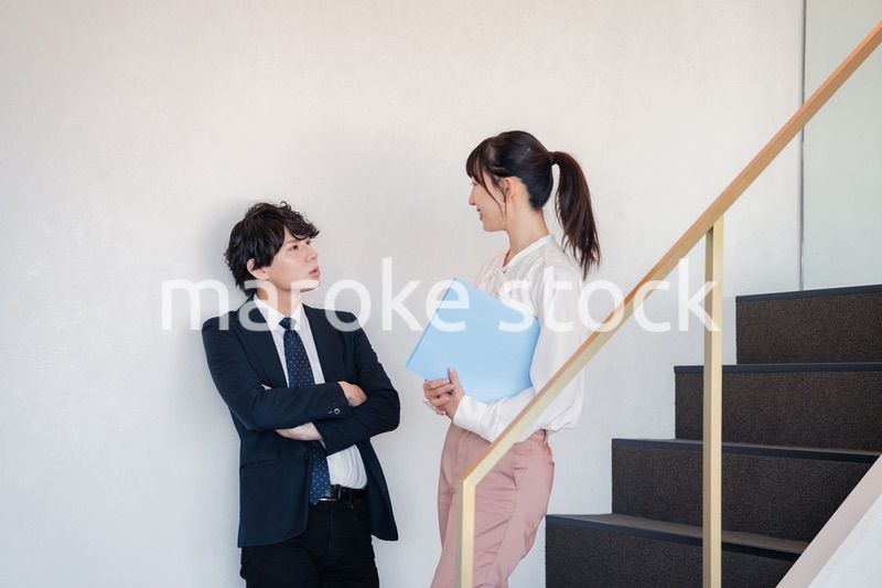 オフィスの階段で立ち話をする先輩と後輩