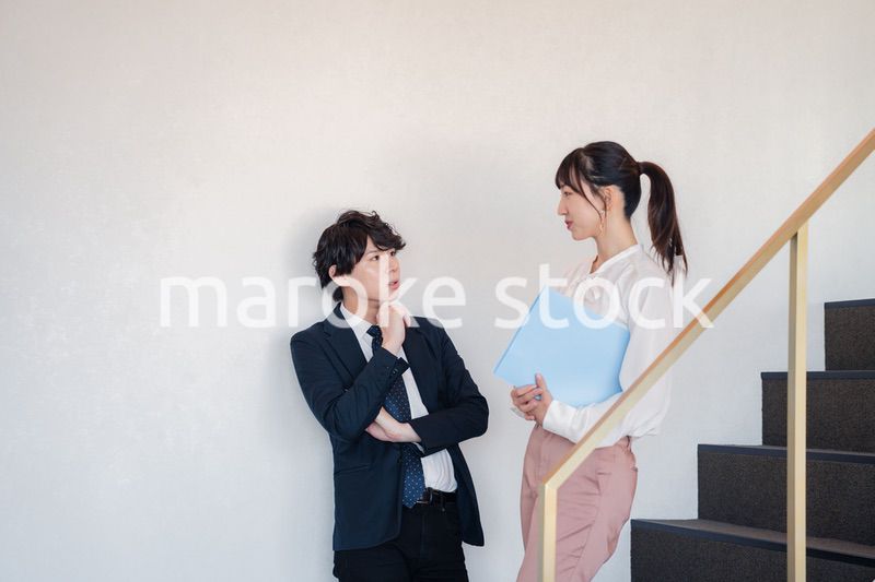 オフィスの階段で立ち話をする先輩と後輩