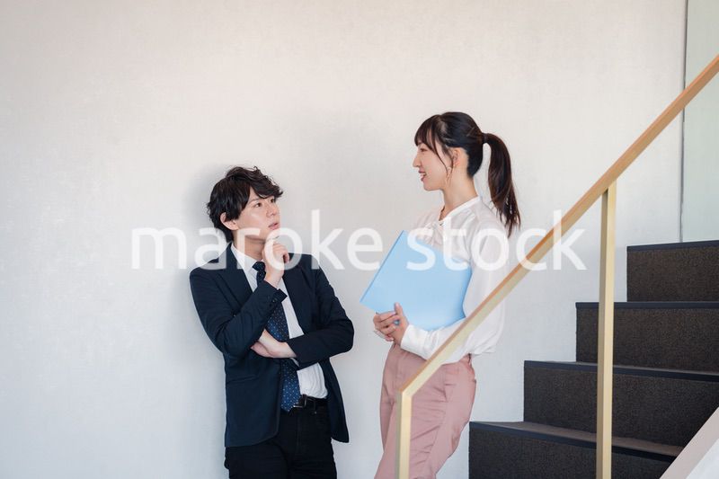 オフィスの階段で立ち話をする先輩と後輩