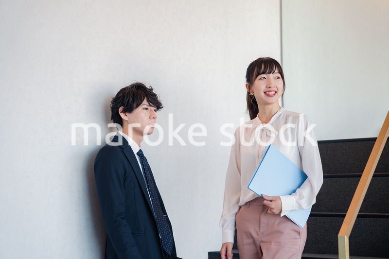 オフィスの階段で立ち話をする先輩と後輩