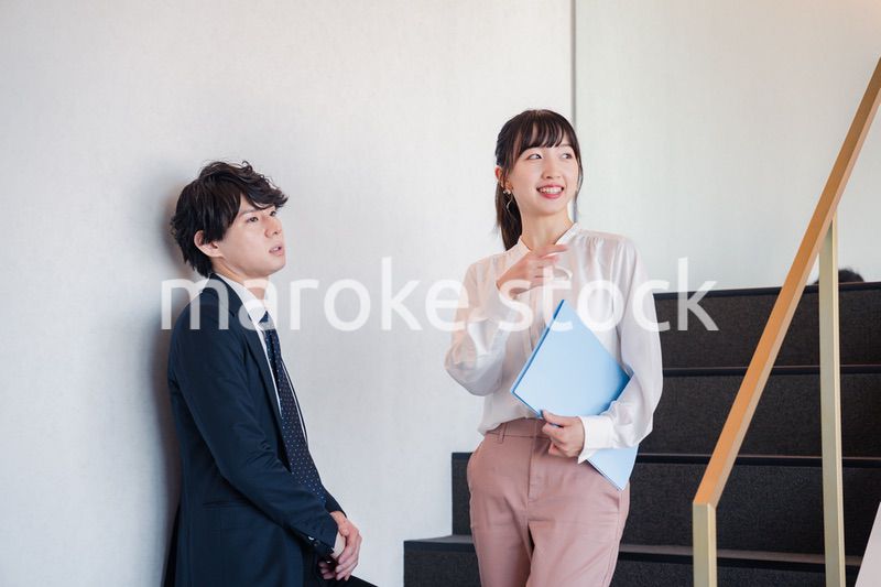 オフィスの階段で立ち話をする先輩と後輩