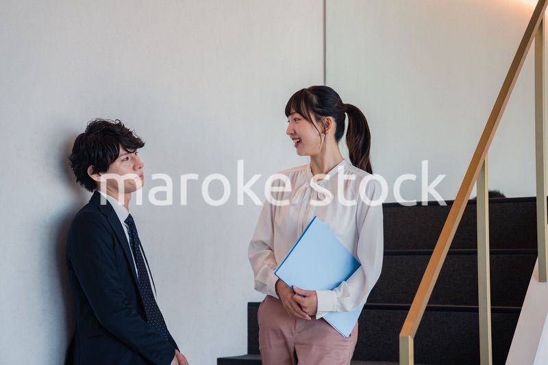 オフィスの階段で立ち話をする先輩と後輩