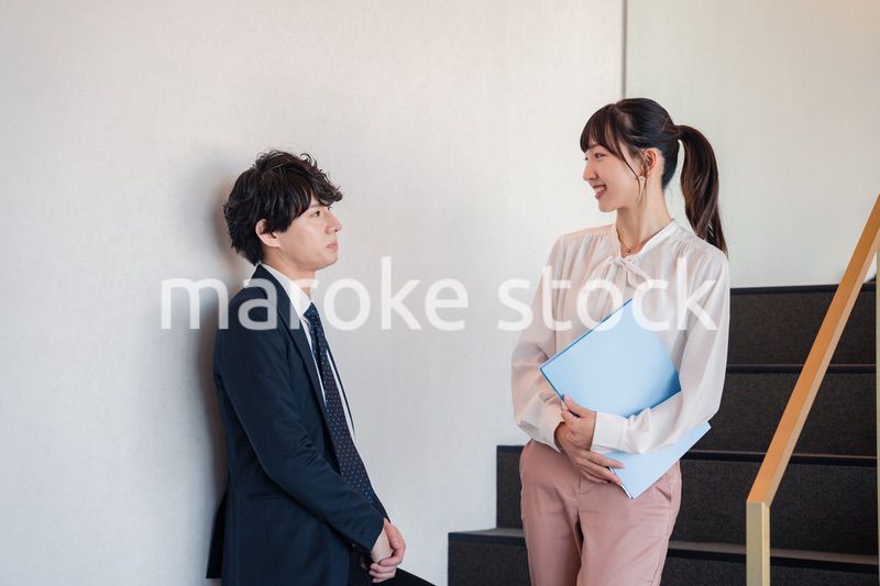 オフィスの階段で立ち話をする先輩と後輩