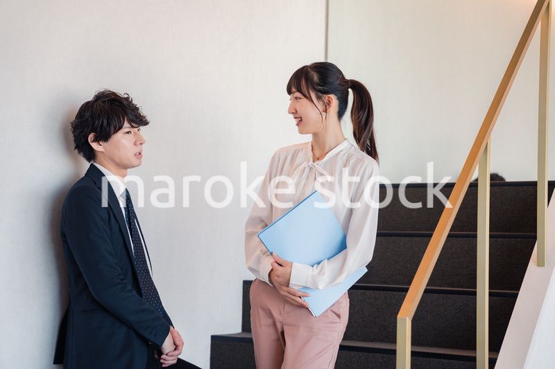 オフィスの階段で立ち話をする先輩と後輩