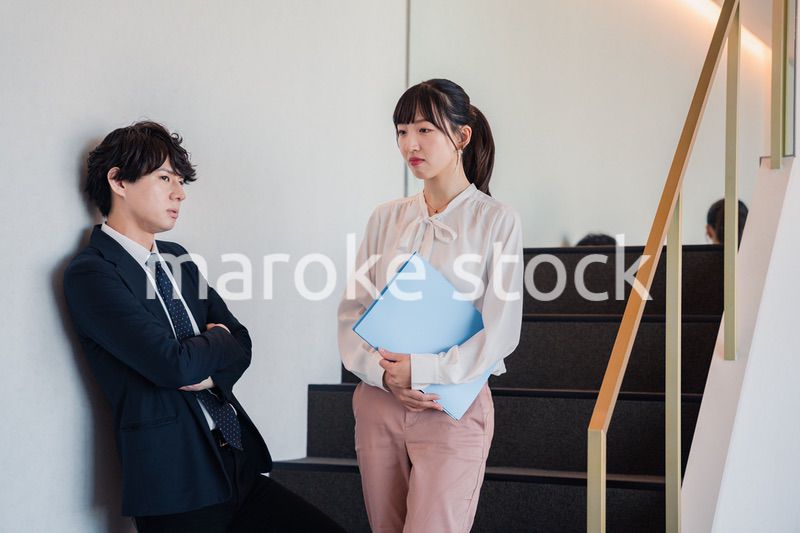 オフィスの階段で立ち話をする先輩と後輩