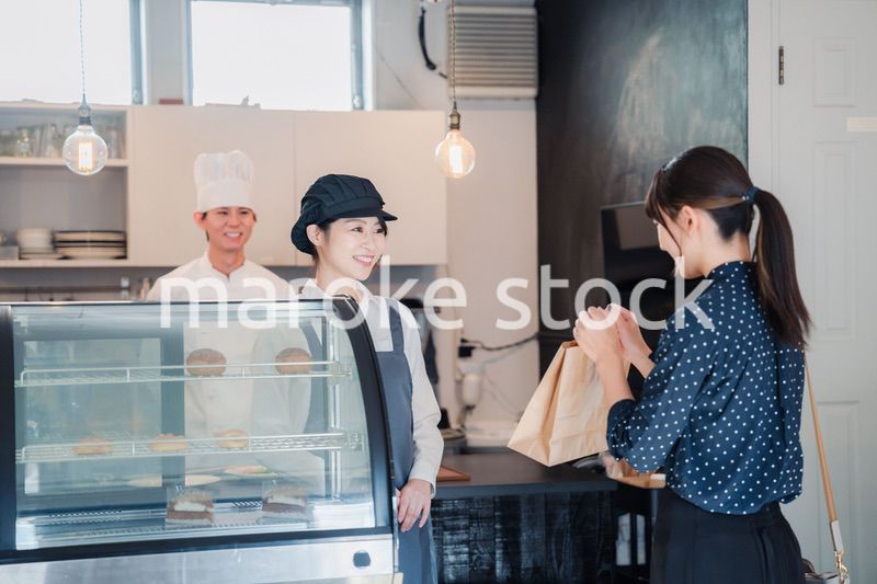 こだわりのお店でテイクアウトをする若い女性