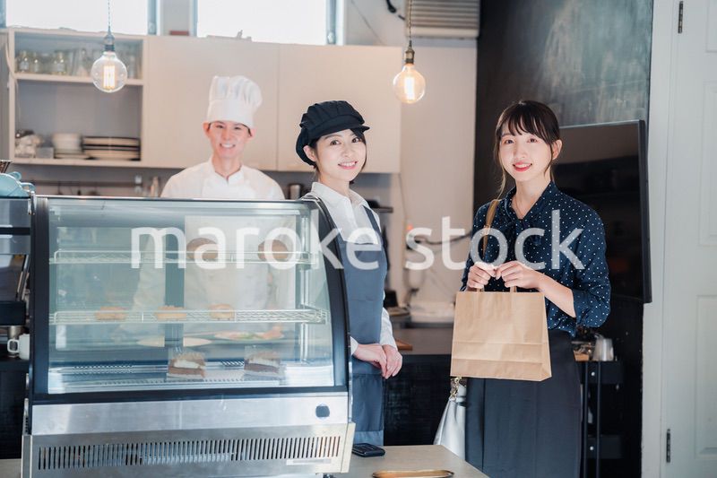 こだわりのお店でテイクアウトをする若い女性