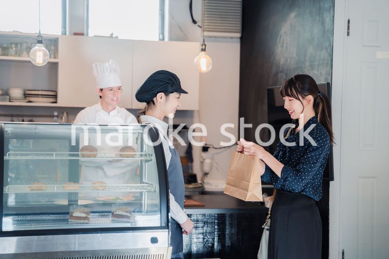 こだわりのお店でテイクアウトをする若い女性