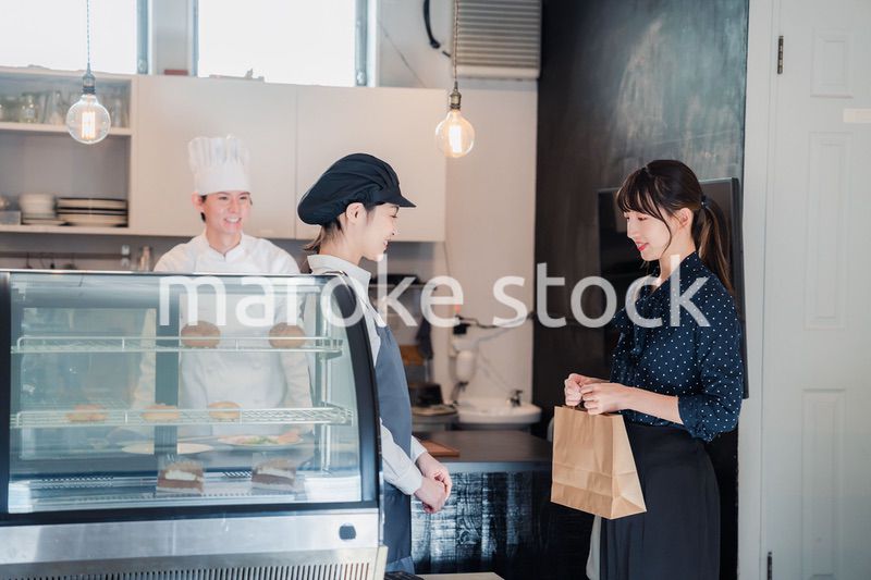 こだわりのお店でテイクアウトをする若い女性