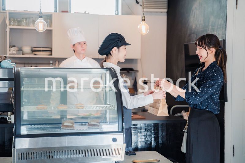 こだわりのお店でテイクアウトをする若い女性