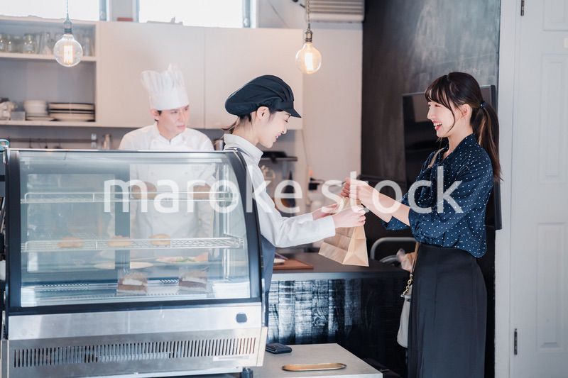 こだわりのお店でテイクアウトをする若い女性